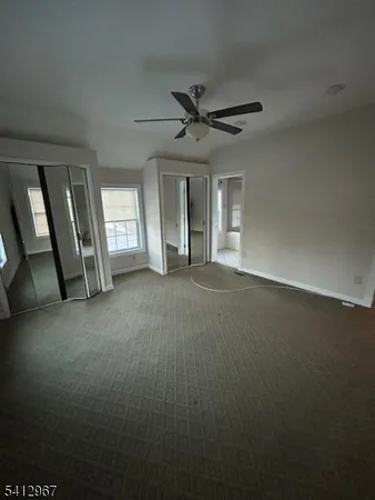 a view of a livingroom with a ceiling fan and window