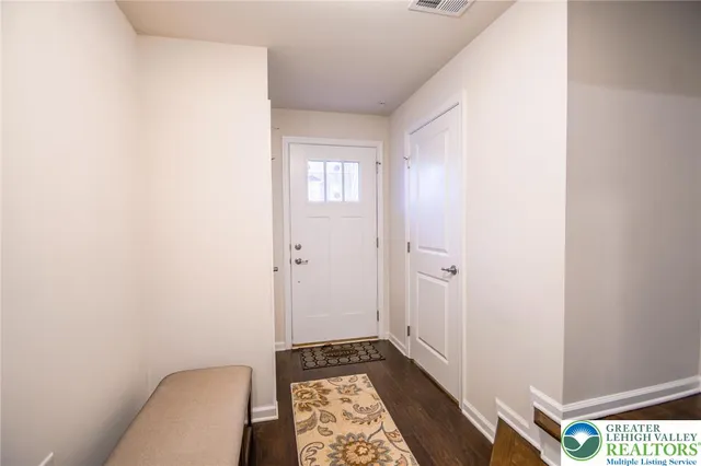 a view of a hallway with entryway and furniture