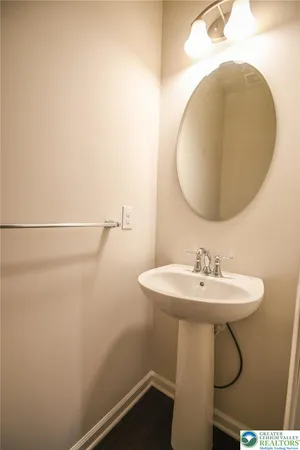 a bathroom with a sink a light fixture and a mirror