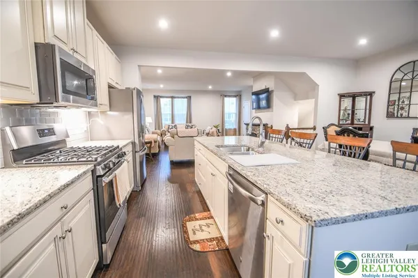 a large kitchen with stainless steel appliances granite countertop a lot of counter space and wooden floor
