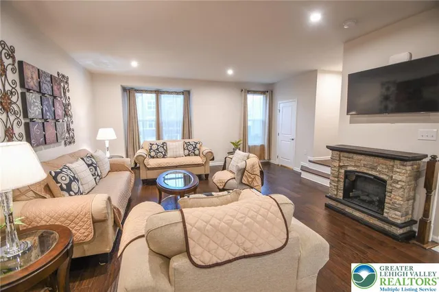 a living room with furniture a flat screen tv and a fireplace