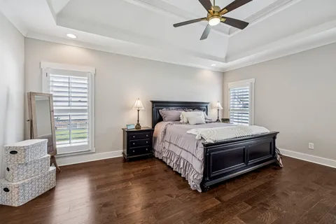 a bedroom with a bed a flat screen tv and a chandelier