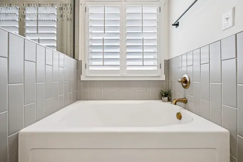 a bathroom with a granite countertop double vanity sink and two mirror
