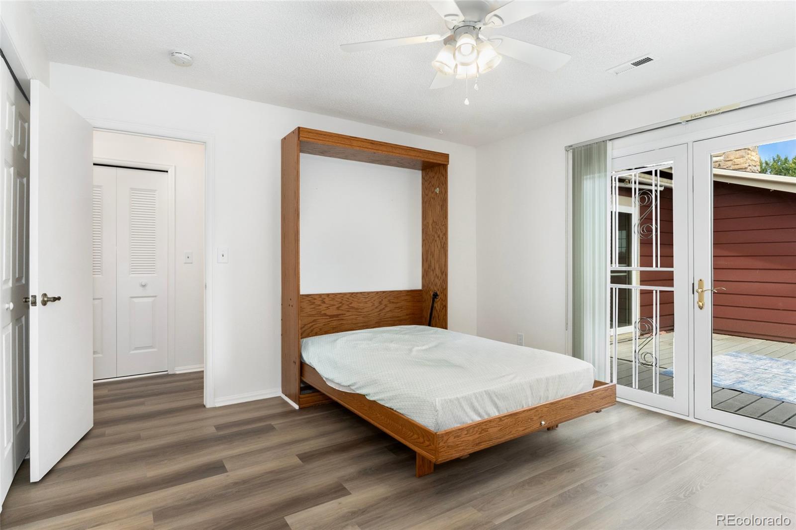 8417 Everett Way, Unit E Arvada, CO 80005 - Photo 11 of 36 a bedroom with a bed and a chandelier