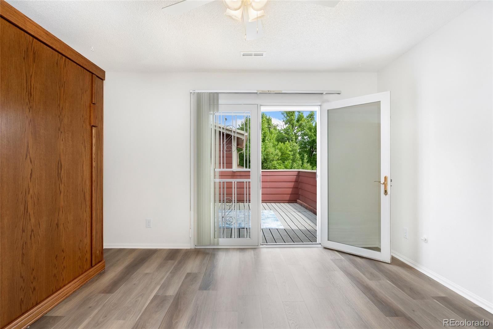 8417 Everett Way, Unit E Arvada, CO 80005 - Photo 13 of 36 an empty room with wooden floor and windows
