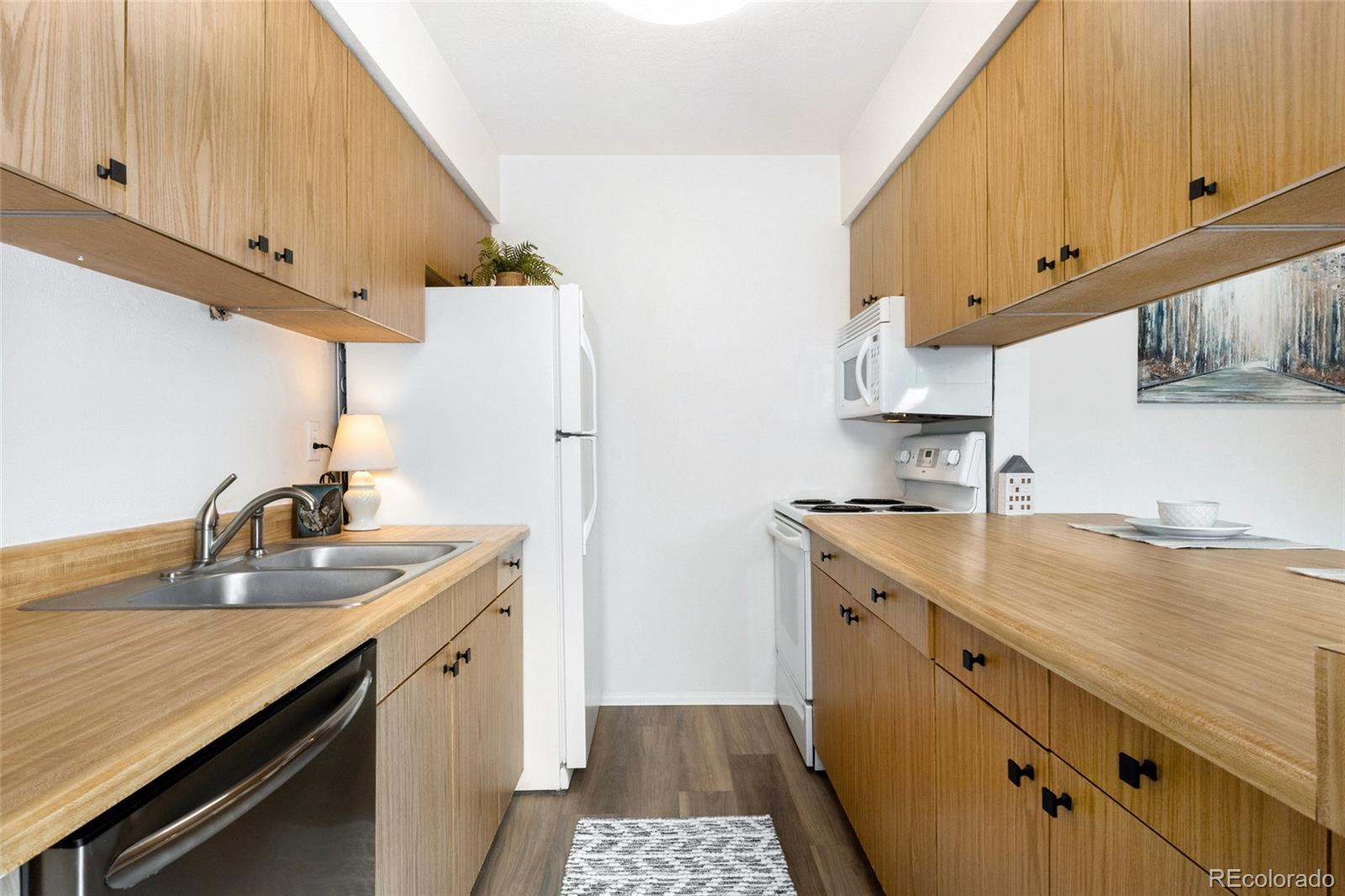 8417 Everett Way, Unit E Arvada, CO 80005 - Photo 15 of 36 a kitchen with a sink stove and cabinets