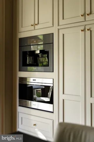 a kitchen with granite countertop white cabinets and stainless steel appliances