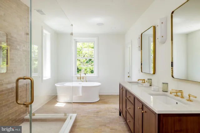 a bathroom with a double vanity sink mirror and bathtub