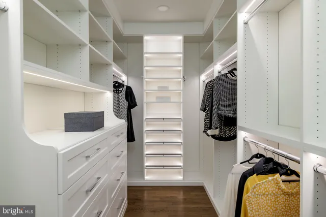 a view of walk in closet with clothes and shoes