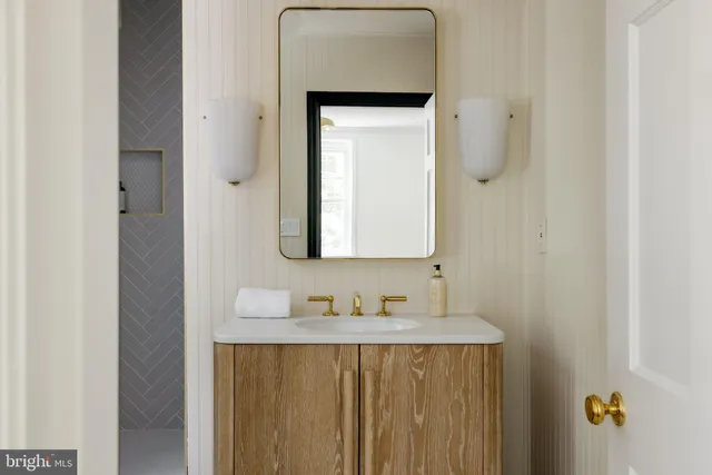 a bathroom with a granite countertop sink and a mirror