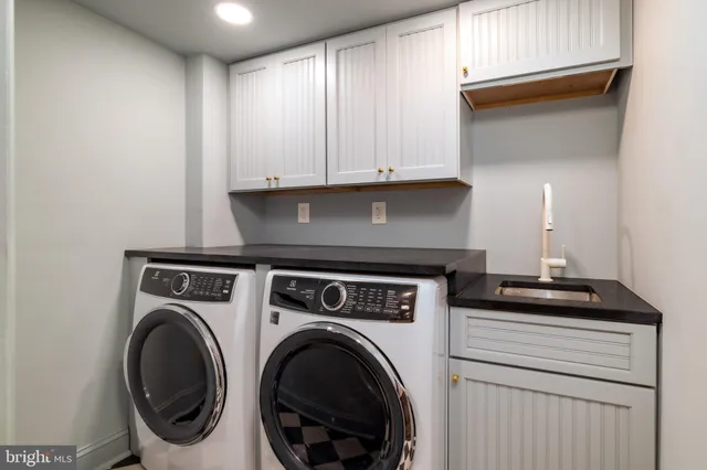 a utility room with sink dryer and washer