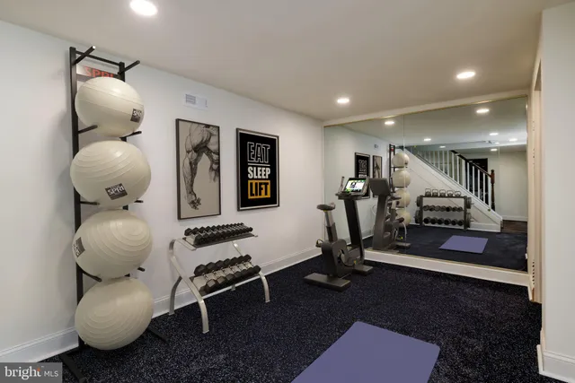 a room with gym equipment and wooden floor