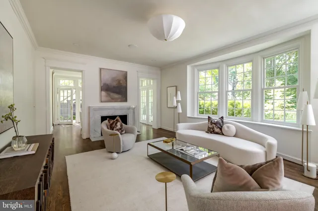 a living room with fireplace furniture and a large window