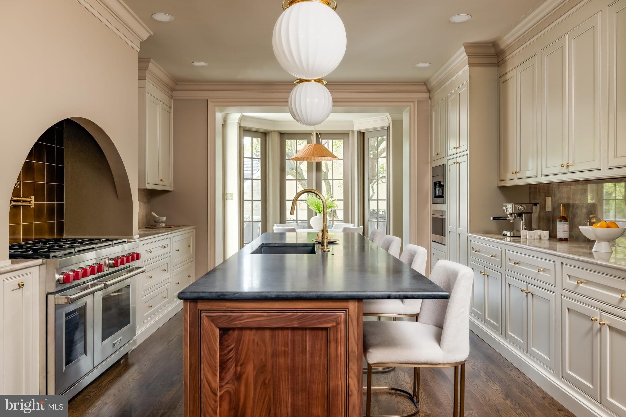 2825 McGill Terrace Northwest Washington, DC 20008 - Photo 8 of 50 a kitchen with stainless steel appliances granite countertop a stove top oven a sink a dining table and chairs with wooden floor