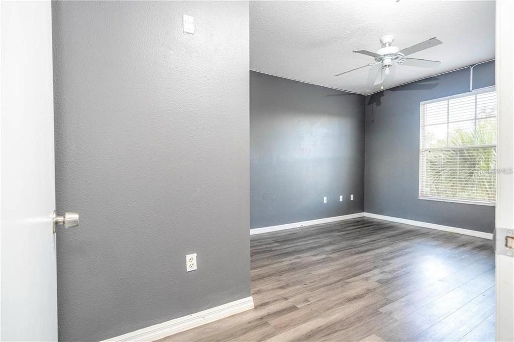 5572 Metrowest Boulevard, Unit 309 Orlando, FL 32811 - Photo 12 of 66 a view of an empty room with a window and a ceiling fan