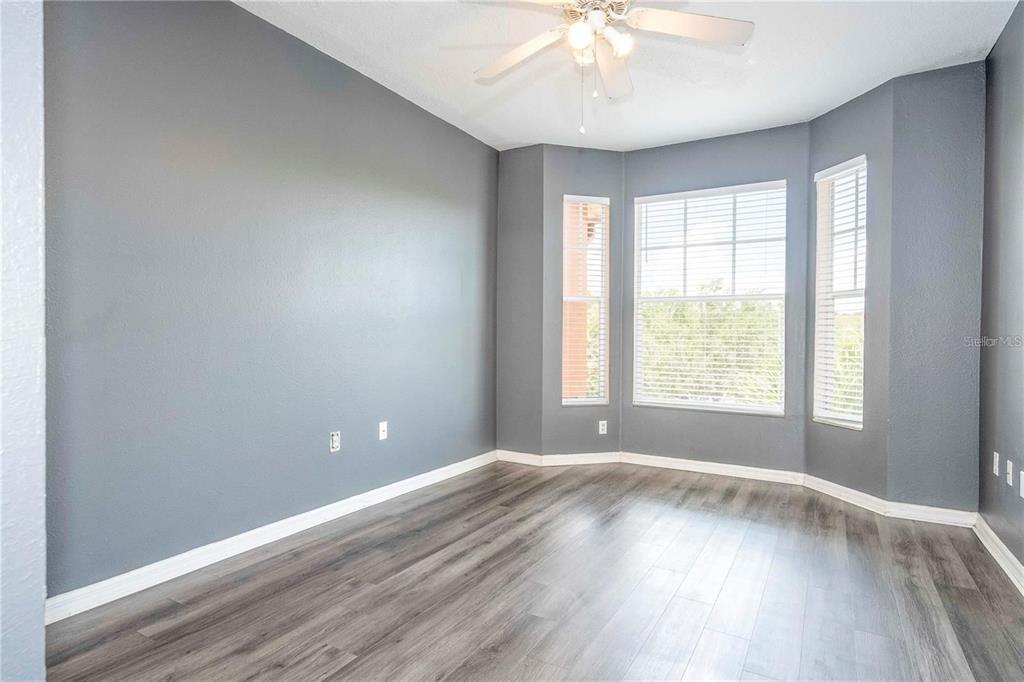5572 Metrowest Boulevard, Unit 309 Orlando, FL 32811 - Photo 16 of 66 an empty room with wooden floor and windows