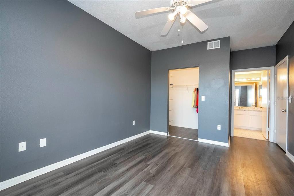 5572 Metrowest Boulevard, Unit 309 Orlando, FL 32811 - Photo 24 of 66 an empty room with wooden floor and windows