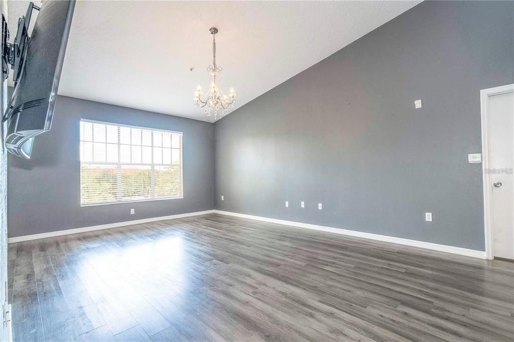 5572 Metrowest Boulevard, Unit 309 Orlando, FL 32811 - Photo 40 of 66 an empty room with wooden floor and windows