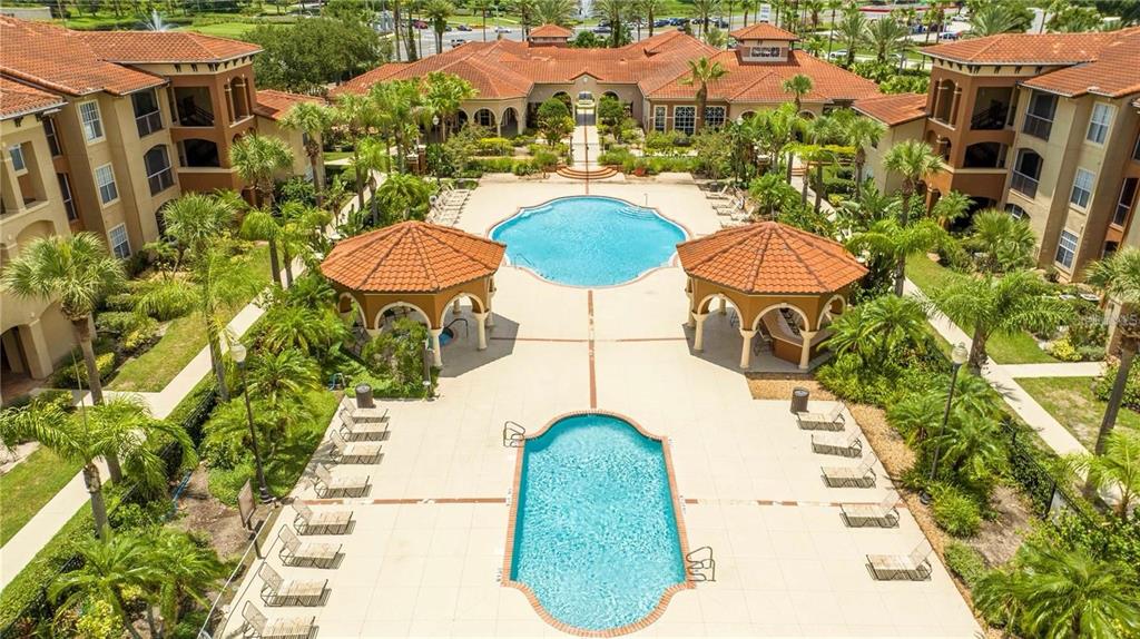 5572 Metrowest Boulevard, Unit 309 Orlando, FL 32811 - Photo 66 of 66 a view of a swimming pool with a chairs and table in the patio