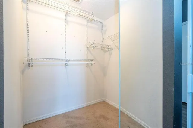 an empty room with wooden floor and fan