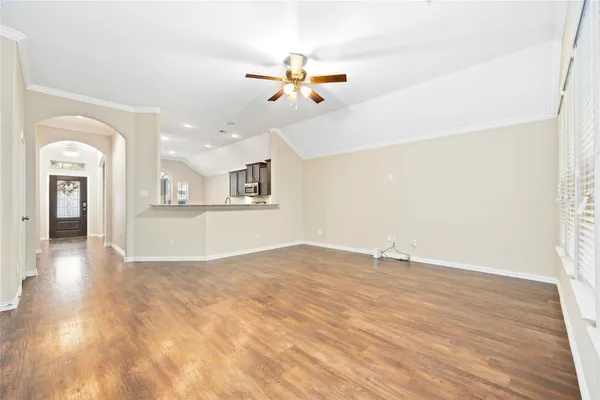 a view of a livingroom with wooden floor and a ceiling fan