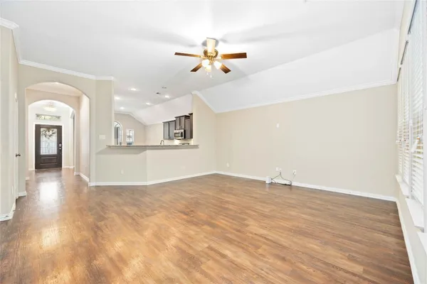 a view of a livingroom with a ceiling fan and wooden floor