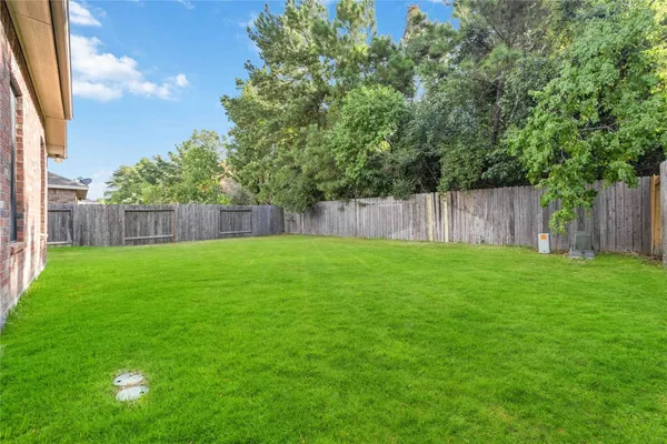 a view of a backyard with a small cabin and wooden fence