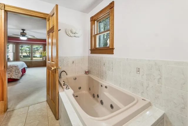 a bathroom with a tub sink and a mirror