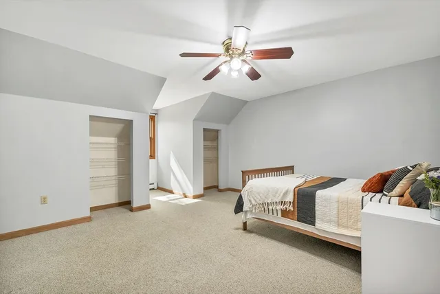 a spacious bedroom with a bed and a ceiling fan