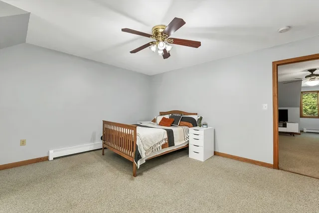 a bed room with a bed and a ceiling fan