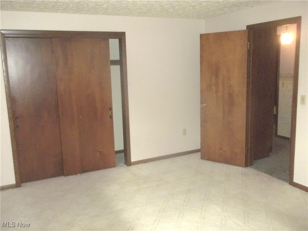 373 May Valley Road Southwest New Philadelphia, OH 44663 - Photo 29 of 38 Unfurnished bedroom featuring a textured ceiling and a closet