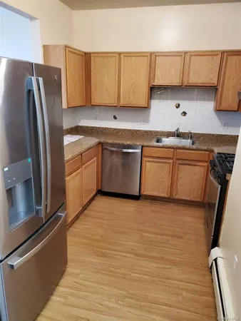 a kitchen with granite countertop a refrigerator stove and sink