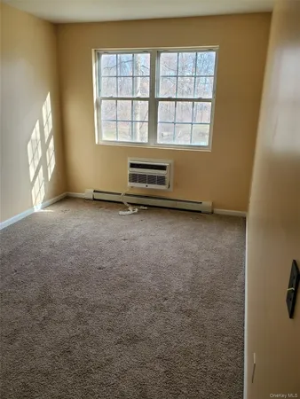 an empty room with a fireplace and windows