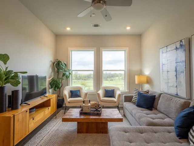 a view of a dining room with furniture a potted plant and wooden floor