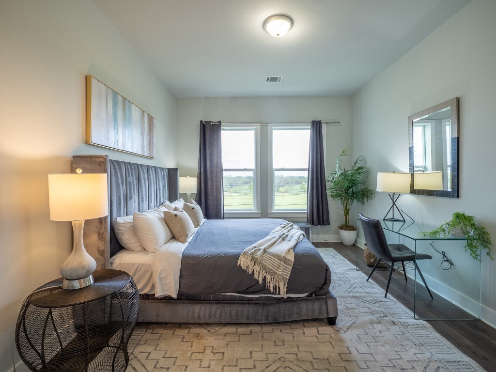 4507 East Martin Luther King Jr Boulevard, Unit 123 Austin, TX 78721 - Photo 12 of 26 Bedroom featuring baseboards and wood finished floors