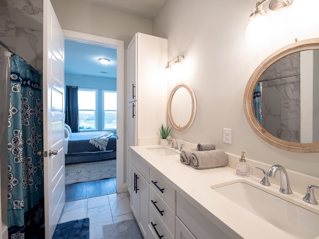 4507 East Martin Luther King Jr Boulevard, Unit 123 Austin, TX 78721 - Photo 14 of 26 Bathroom with a marble finish shower, ensuite bath, double vanity, and light marble finish flooring