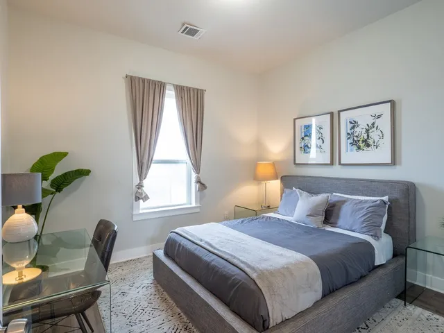 a bedroom with a bed window and couch