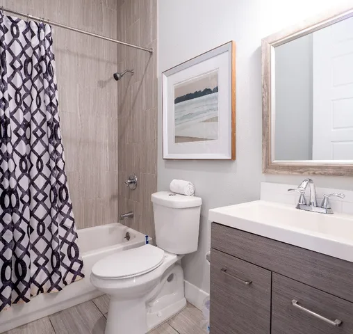 a en suite bathroom with a granite countertop sink and a mirror