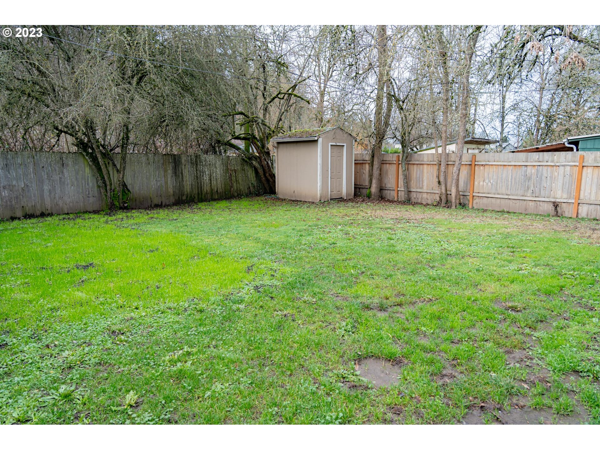 938 Water Street Springfield, OR 97477 - Photo 27 of 28 a view of a backyard with large trees and wooden fence