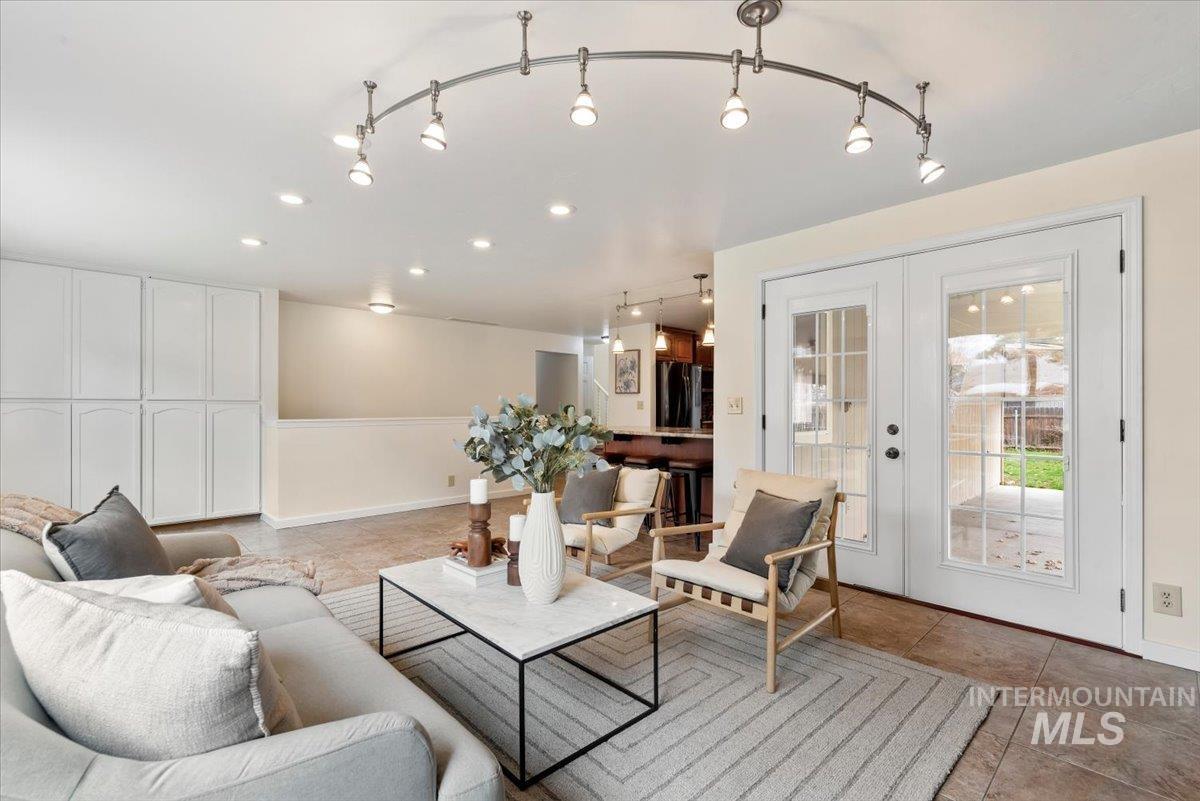 4297 Nystrom Way Boise, ID 83713 - Photo 11 of 50 Living area with rail lighting, French doors, and light tile floors, built-in cabinetry