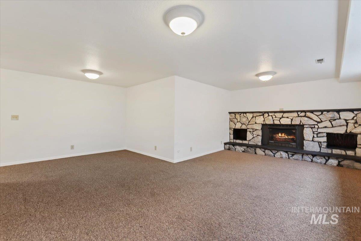 4297 Nystrom Way Boise, ID 83713 - Photo 27 of 50 Basement Living room featuring a stone fireplace and carpet