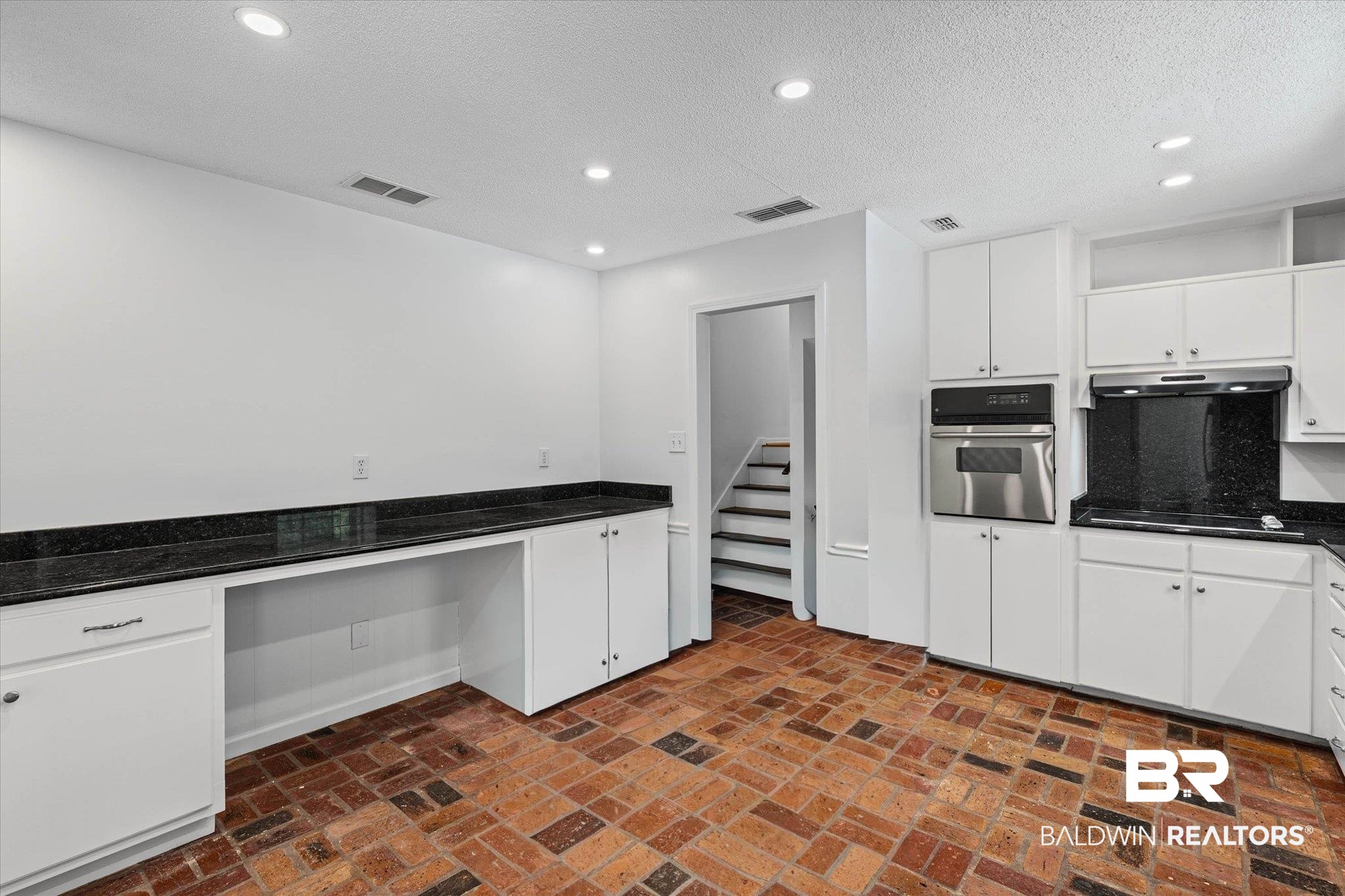 8301 Fordham Road Mobile, AL 36619 - Photo 10 of 57 Kitchen area featuring brick flooring, white cabinetry, dark stone countertops, a built-in wall oven, and recessed lighting