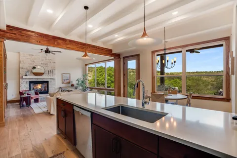 a large kitchen with kitchen island a large window in it