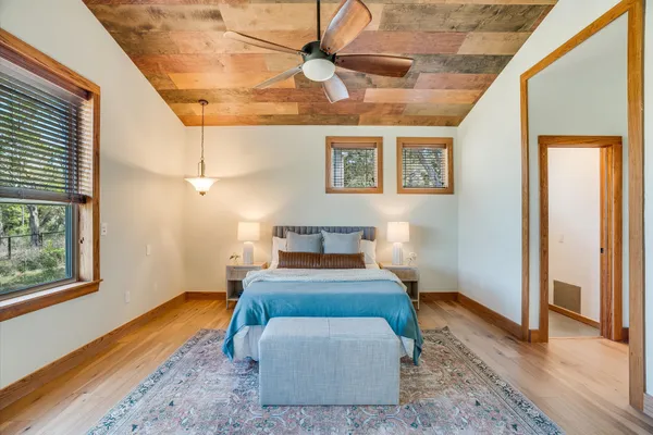 a bedroom with a bed and wooden floor