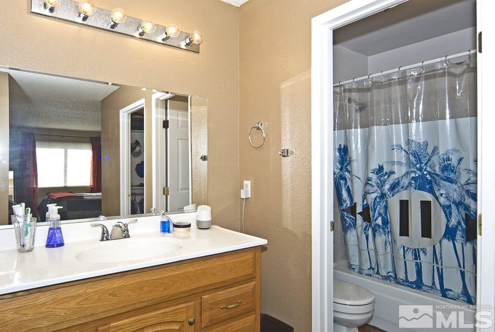 2095 Highview Court, Unit 7 Reno, NV 89512 - Photo 18 of 24 a en suite bathroom with a granite countertop sink a toilet a mirror and shower
