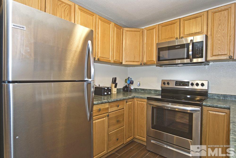 2095 Highview Court, Unit 7 Reno, NV 89512 - Photo 7 of 24 a kitchen with stainless steel appliances granite countertop a refrigerator a stove a sink and a microwave