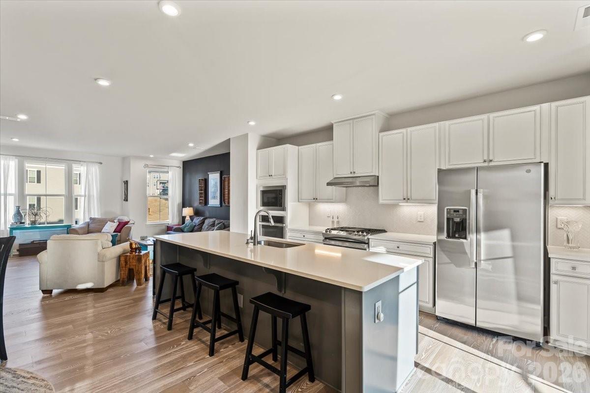 a kitchen with a dining table chairs refrigerator and cabinets