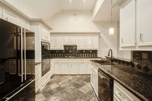 a kitchen with granite countertop a refrigerator and a stove top oven