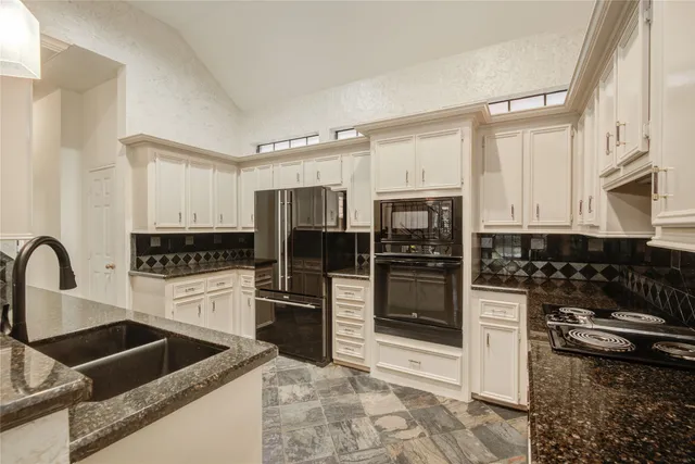 a kitchen with granite countertop a stove and a sink