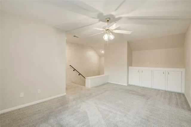 an empty room with closet and a ceiling fan